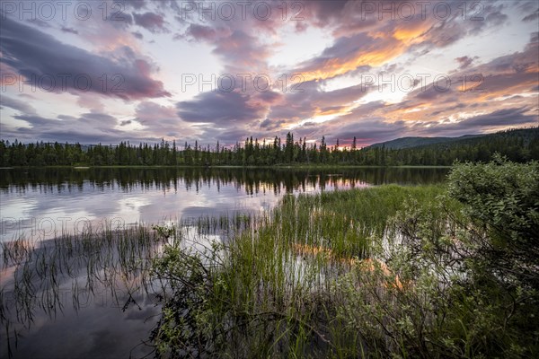 Dramatic sunset by the river Namsen with reflection