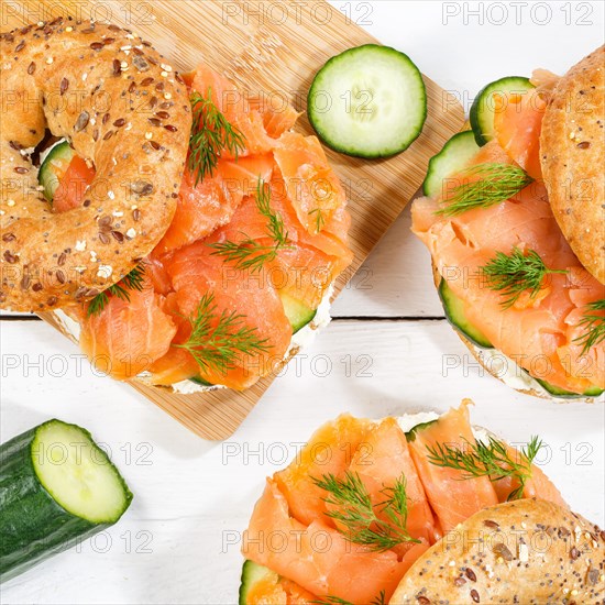 Bagel sandwich for breakfast topped with salmon fish from above on a wooden board square in Stuttgart