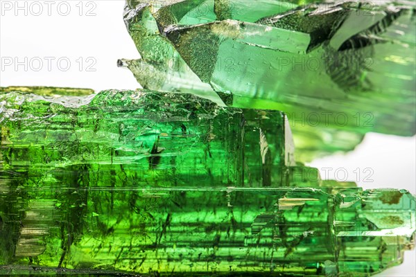 Two brazilian green tourmaline raw crystal with white background