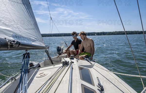 Two young men sailing on a sailboat