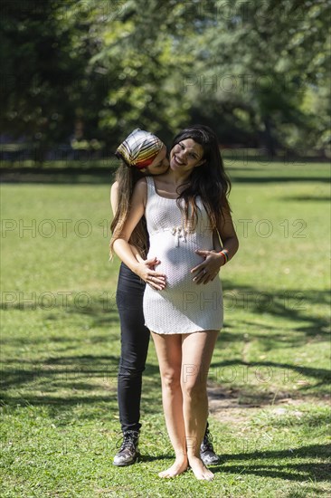 Happy pregnant lesbian couple at outdoors. LGBT