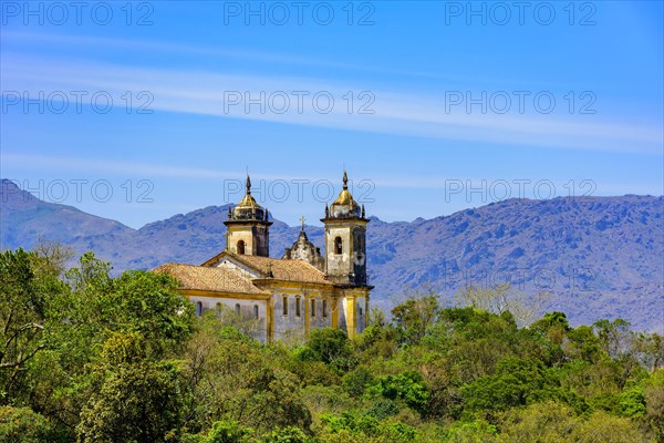 Rear view of historic church in baroque and colonial style from the 18th century amid the hills and vegetation of the city Ouro Preto in Minas Gerais