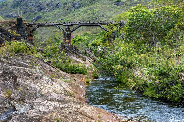Stream through the vegetation of the Biribiri reserve in Diamantina with an old wooden bridge built by slaves to drain the production of diamonds and destroyed by time