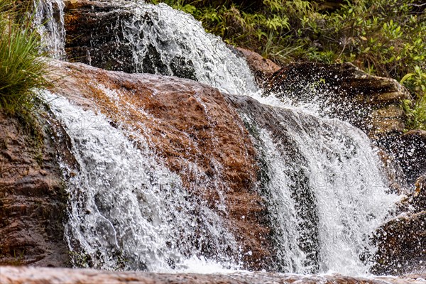 Detail of a small waterfall with water running over the rocks of the Biribiri environmental reserve in Diamantina