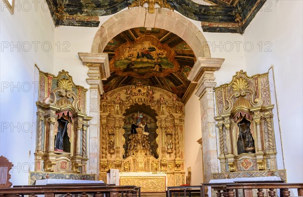 Interior and altar of a brazilian historic ancient church from the 18th century in baroque architecture with details of the walls in gold leaf in the city of Tiradentes