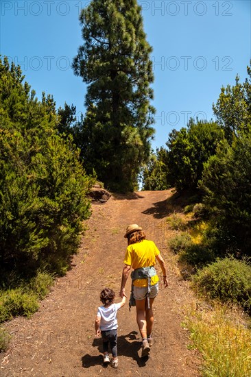 A mother with her son walking up a hill on the La Llania trekking trail in El Hierro