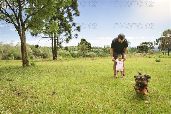 Cute baby learns to take her first steps with her dad