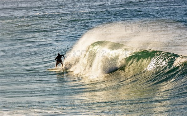 Surfer on a wave at Ipanema beach in Rio de Janeiro at dawn