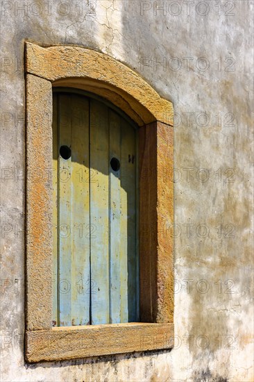 Historic church window in colonial style with stone frame in the ancient city of Ouro Preto in Minas Gerais