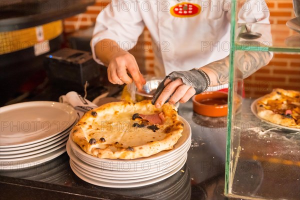 Artisan pizza oven. Chef preparing the pizza to sell it