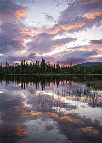 Dramatic sunset by the river Namsen with reflection