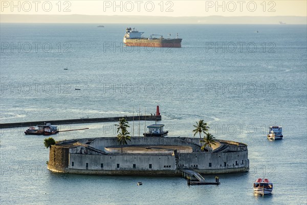 Old fortress of Sao Marcelo during sunset surrounded by the waters of the sea of Salvador and built in the 17th century