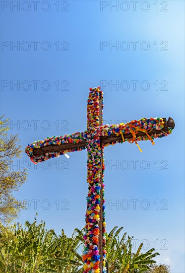 Crucifix decorated with flowers with blue sky in the background common in traditional religious festivals in the interior of Brazil in the state of Minas Gerais
