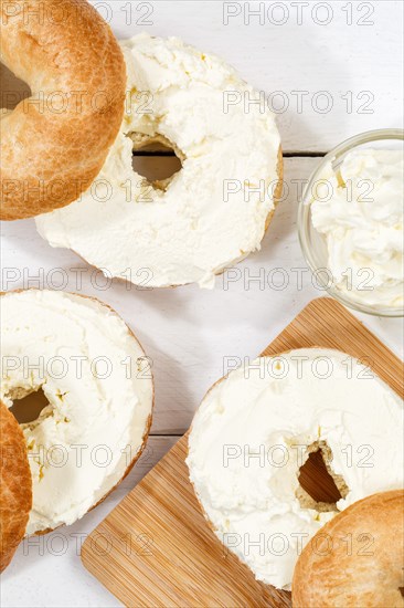 Bagel sandwich for breakfast topped with cream cheese on wooden board from above in Stuttgart