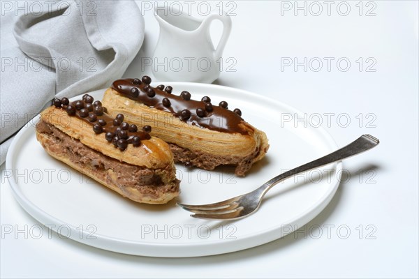 Two chocolate eclairs on a plate