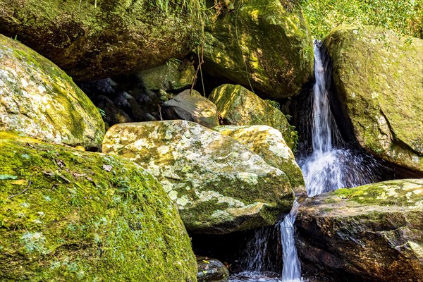 Small waterfall among mossy rocks and rainforest on Ilhabela island on the north coast of Sao Paulo