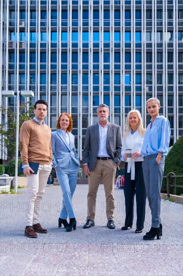 Portrait of cheerful group of coworkers walking outdoors in a corporate office area