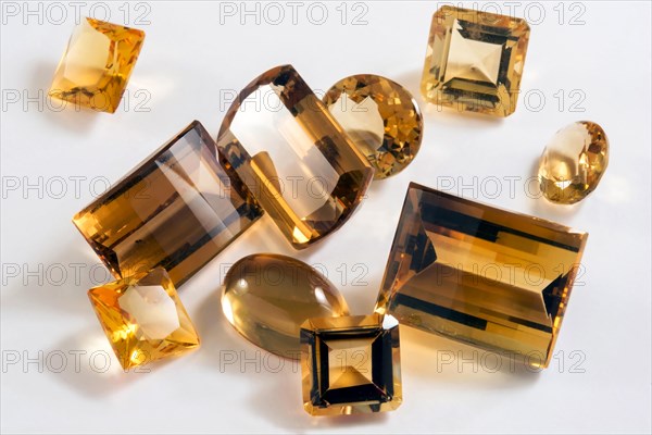 Several yellow citrine stones with different types of cutting in white background