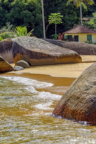 Deserted beach with small abandoned hut surrounded by rainforest on Ilha Grande