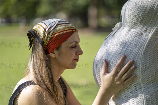 Young woman holding his pregnant girlfriend's tummy