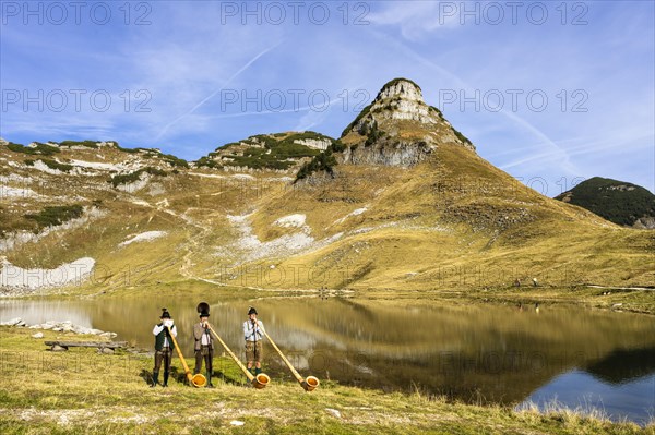 The Austrian alphorn trio Klangholz plays the alphorn at the Augstsee on Mount Loser