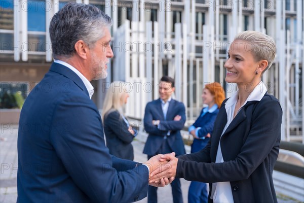 Successful Executives Congratulating Each Other in a Commercial Hub