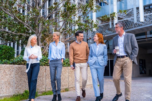 Group of coworkers walking outdoors in a corporate office area