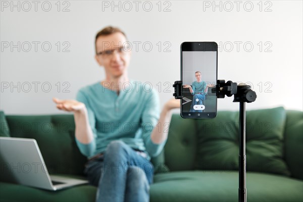 A middle-aged man finishes the online broadcast from home and spreads his arms to the sides