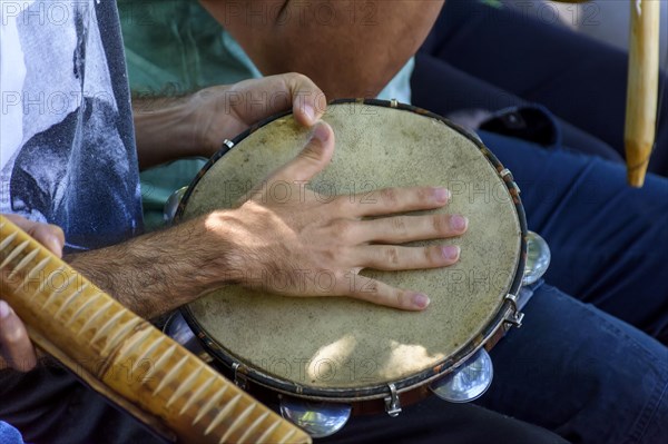 Tambourine player and other instrumentalists during a Brazilian samba performance at the carnival