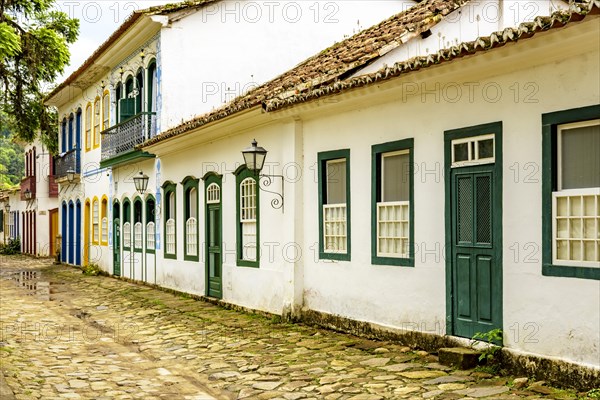 Rua bucolica com calcamento de pedras e casas historicas em estilo colonial da epoca do imperio na cidade de Paraty no litoral do Rio de Janeiro