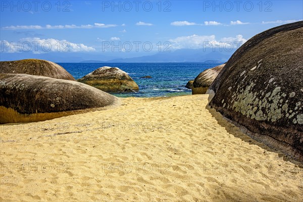 Paradisiacal beach of green and transparent waters surrounded by rocks in Ilha Grande