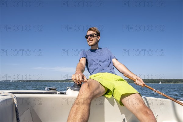 Young man sailing on a sailboat