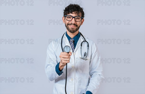 Young doctor holding blood pressure monitor. Handsome doctor showing blood pressure monitor isolated