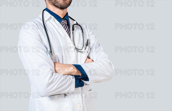 Young doctor with crossed arms isolated. Unrecognizable doctor with crossed arms on isolated background
