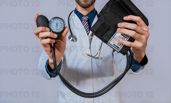 Doctor holding blood pressure monitor isolated. Doctor hands holding manual sphygmomanometer isolated