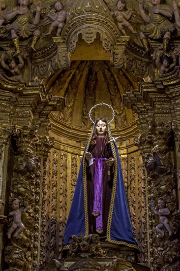 The crying saint. Sculpture in 18th century Brazilian Baroque sacred art surrounded by angels and present in the interior of the rich churches of Ouro Preto in Minas Gerais