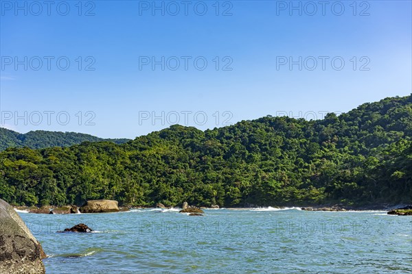 Paradise rocky tropical beach with mountains and forests around in coastal Bertioga of Sao Paulo state