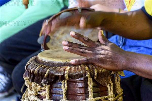 Musician playing a rudimentary percursion instrument called atabaque during afro-brazilian capoeira cultural manifestation