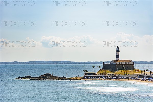 Barra beach and lighthouse seen from afar with the summer sun of Salvador in Bahia