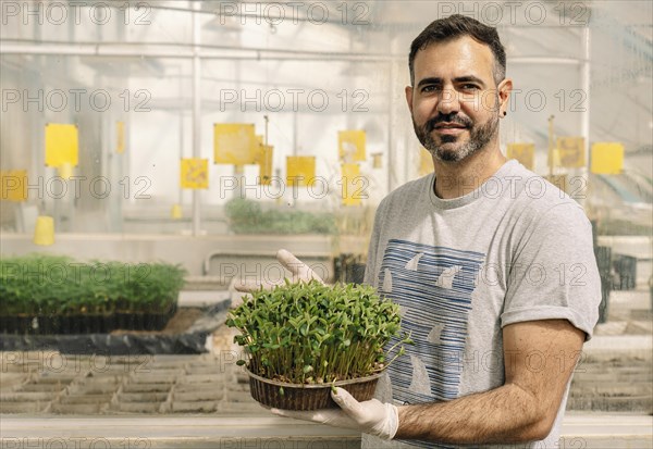 Male researcher smiles and looks at camera