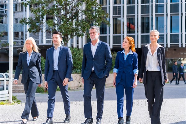 Building Connections: Five Executives Walking and Laughing in a Commercial Area