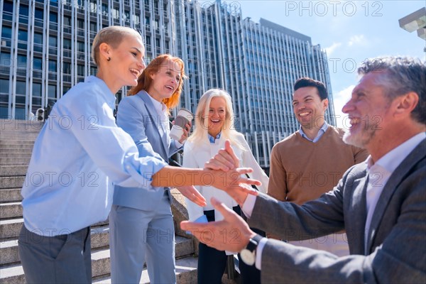 Greeting and shaking hands coworker. Group of executives or business people outdoors in a corporate office area