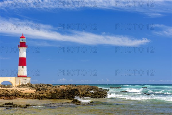 Colorful lighthouse on the sands of the famous Itapua beach in the city of Salvador in Bahia