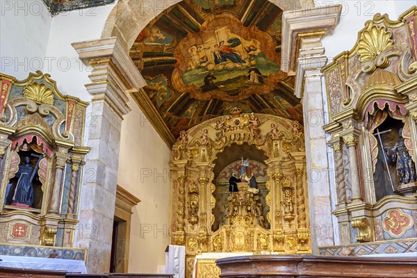 Interior and altar of a brazilian historic ancient church from the 18th century in baroque architecture with details of the walls in gold leaf in the city of Tiradentes