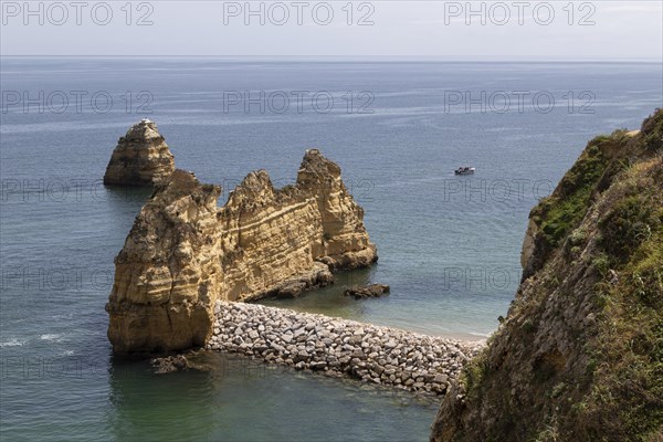 Breakwater at Praia do Pinhao on the rocky coast of Lagos