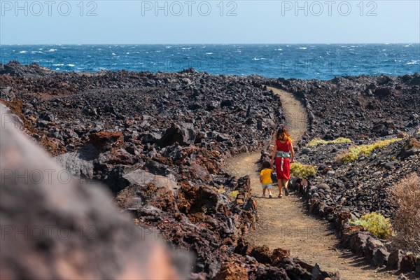 Walking along the beautiful volcanic path in the town of Tamaduste on the coast of the island of El Hierro