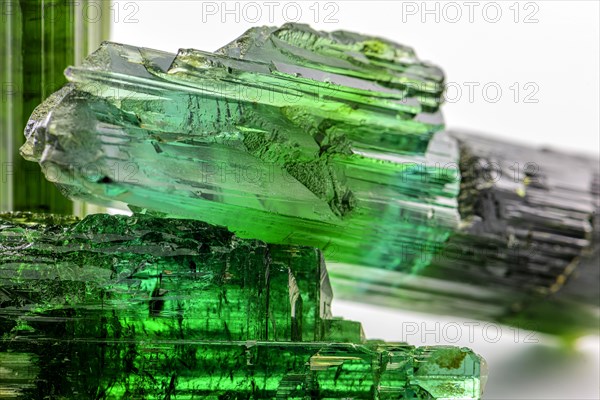 Three brazilian green tourmaline raw crystal with white background