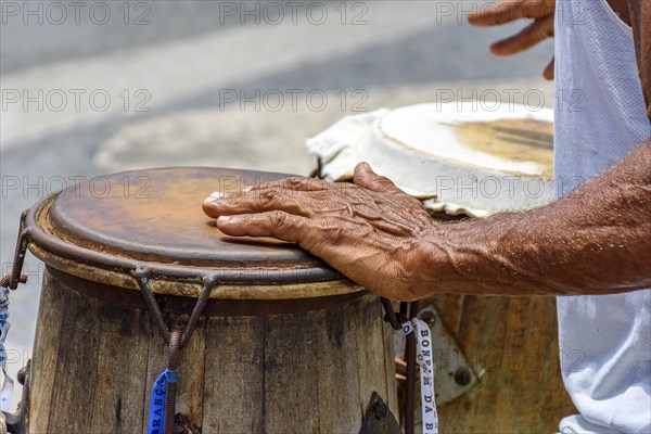 Musician playing a traditional Brazilian percussion instrument called atabaque during a capoeira performance on the streets of Pelourinho in Salvador