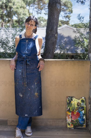 Portrait of a smiling woman artist looking at camera outdoors