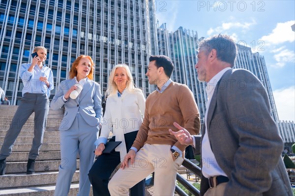 Speaking in a relaxed moment at halftime. Group of coworkers outdoors in a corporate office area